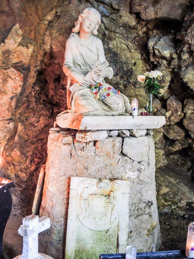 Beeld van Maria Magdalena tegen de rotswand in haar grot in de Sainte-Baume. Foto: Espirat, CC BY-SA 4.0